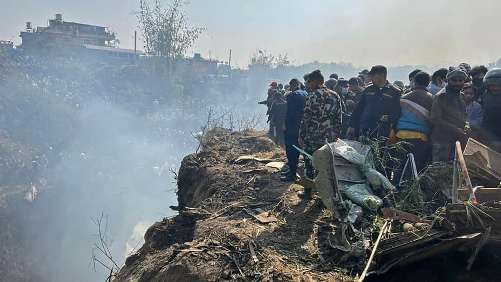 Rescuers and onlookers gather at the site of a plane crash in Pokhara on January 15, 2023