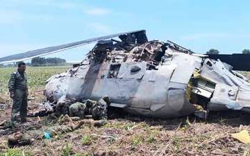 Emergency personnel work next to a Mexican navy helicopter that crashed after providing support for the operation that captured drug lord Rafael Caro Quintero, near Los Mochis, Sinaloa state, Mexico, 